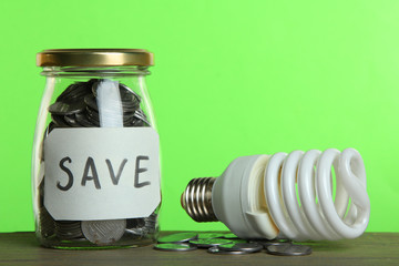 Money in a glass jar and a light bulb