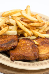 Stewed pork chops with french fries on the plate