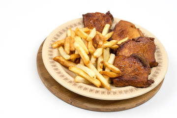Baked pork chops with french fries served on the plate