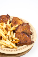 Baked pork chops with french fries served on the plate