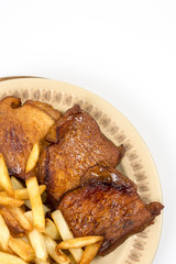 Baked pork chops with french fries served on the plate