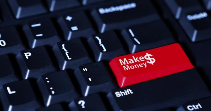Male finger presses a button with red color and text of Make Money on the computer keyboard
