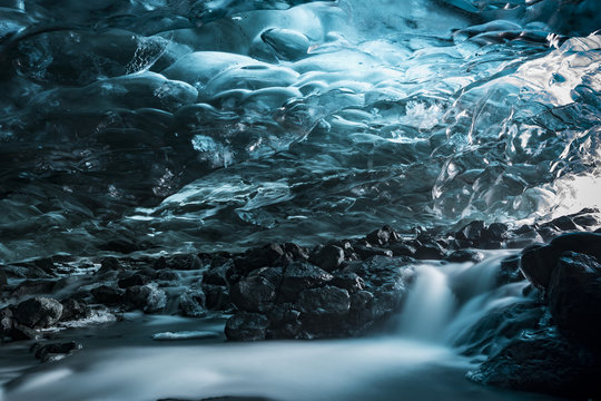 Blue glaciar ice cave abstract interior with river, long exposition
