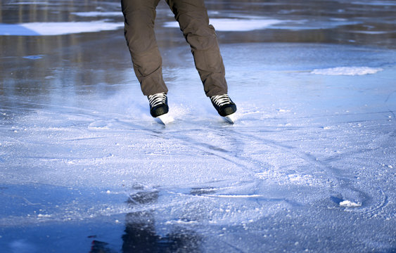 The guy rides on skates on ice in the winter.