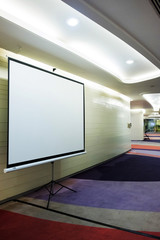 Front view of lecture room with empty white projector screen