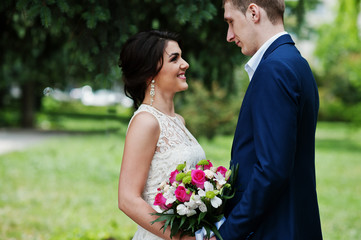 Happy stylish loved couple in love at green spring background.