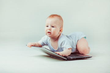 Little child lies on a laptop