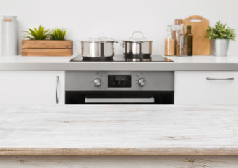 Bleached wooden texture table on defocused kitchen stove interior background