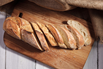 Sliced baguette on wood board.