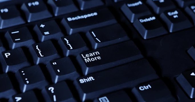 Male finger pressing a Learn More button on the computer keyboard