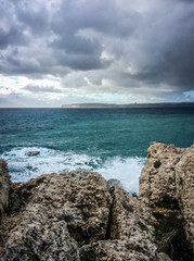 Big waves breaking on the shore with sea foam