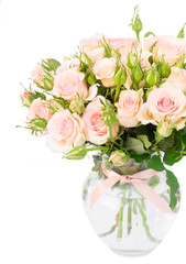 Bouquet of pink fresh roses with buds in glass vase close up isolated on white background
