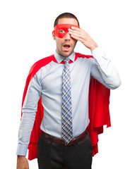 Scared super businessman covering his eyes