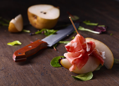 prosciutto with pear on a wooden table