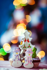 Gingerbreads in form of snowmen stand on dinner table