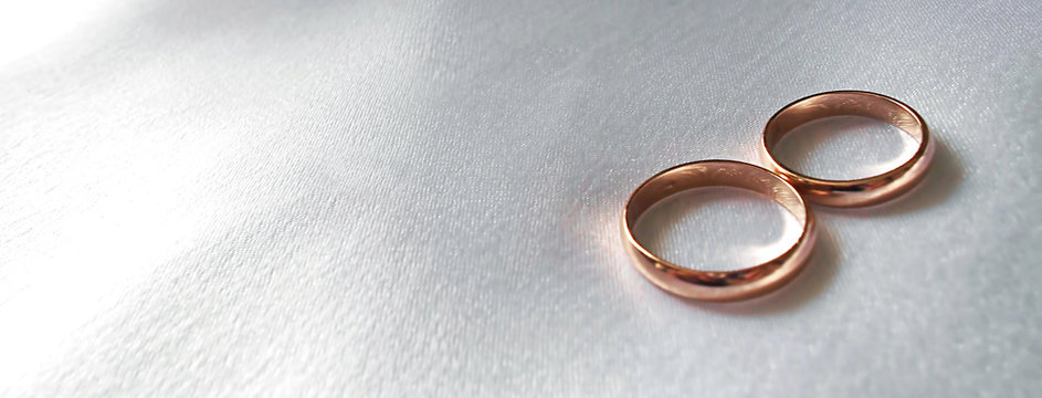 Gold wedding rings on white fabric