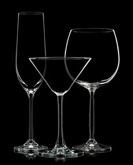 Silhouette of different glasses on black background.