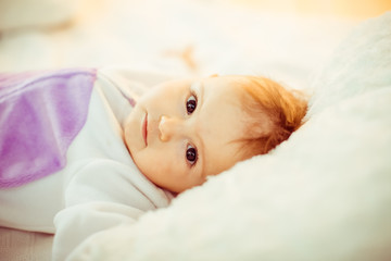 Girl in violet suit lies on soft pillows