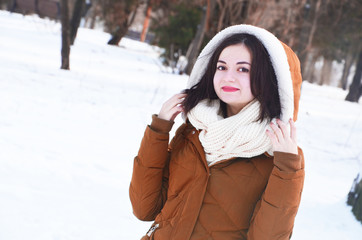 Beautiful young smiling woman in the park in winter sunny day.