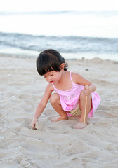 Portrait Kid girl playing sand at the beach