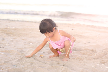 Portrait Kid girl playing sand at the beach