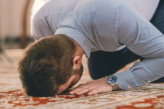 Muslim prostrating on the ground floor while praying