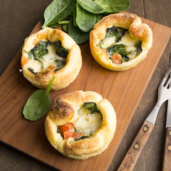 tartlet cheese and spinach on a wooden table