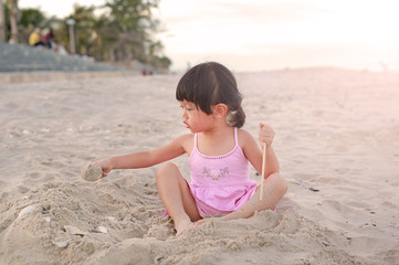 Portrait Kid girl playing sand at the beach
