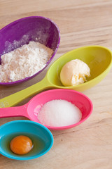 baking recipe ingredients table top view with measuring spoons and kitchen table