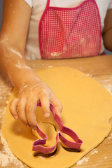 kid hands making cookies, cutting the dough with the molding trim 
