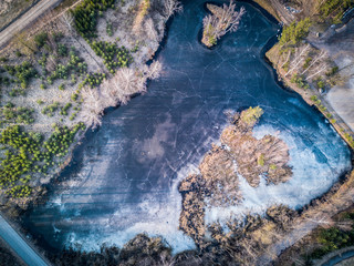 Aerial shot of lake with cracked ice cover - spring is coming, nature wakes up / Dji Mavic Pro drone