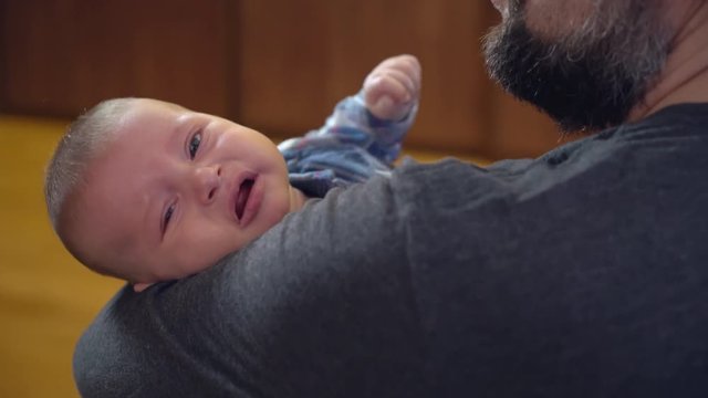 father holding baby. back view man soothes child. Little boy cry in daddy s arms.