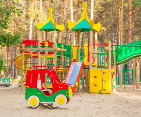 Fototapeta na wymiar Playground with swings, slides and stairs in a pine forest