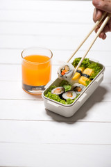 Orange juice and bento box with different food, fresh veggies and fruits