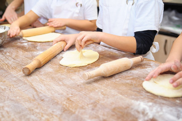 Young children make dough. Hands close up