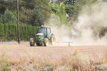Tractor Working in a Dusty Field
