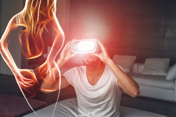 Young man with VR headset playing with fiery sexy woman silhouette, virtual reality