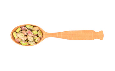 Pistachio nuts without shell in a wooden spoon on a white background, top view