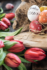 Obraz na płótnie Canvas Frohes Osterfest mit roten Tulpen