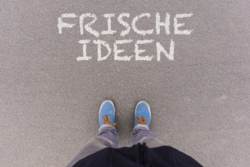 Frische Ideen, German text for Fresh Ideas text on asphalt ground, feet and shoes on floor