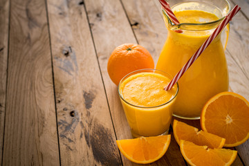 Freshly made orange juice on beautiful wooden background.
