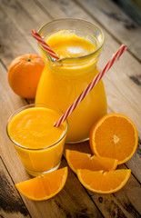 Freshly made orange juice on beautiful wooden background.
