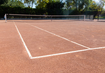 Orange brown sand empty private tennis court ready for game