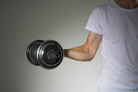 Young Man in a white shirt doing biceps exercises.