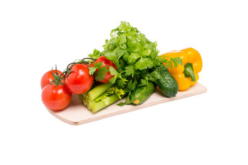 Ассорти из свежих овощей на деревянной доске на белом фоне