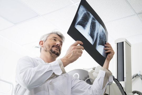 Male Radiologist Analyzing Chest X-ray In Examination Room