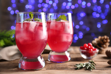 Glasses of delicious wine spritzer on blurred lights background