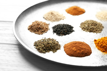 Tray with mix of different spices on wooden table