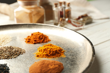 Tray with mix of different spices on wooden table