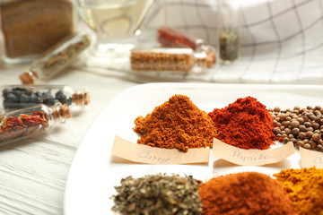Plate with mix of different spices on wooden table